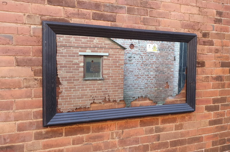 A reclaimed silver-backed mirror, preserved and framed in a hand-ebonised oak frame